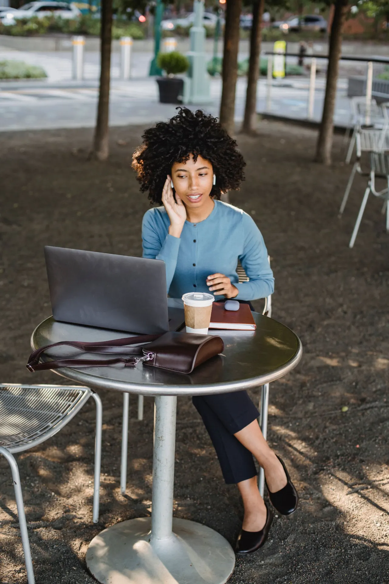 A job seeker working on a laptop at an outdoor cafe table